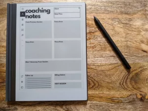 Carnet de note + stylo pour prendre des note. L'arrière plan est une table en bois