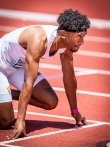 A male runner in starting blocks on a track