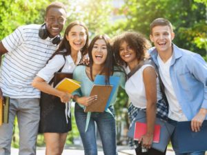 étudiants souriant avec des cahiers scolaire 